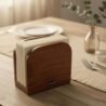 Elegant wooden napkin holder with white paper napkins for dining table decor.