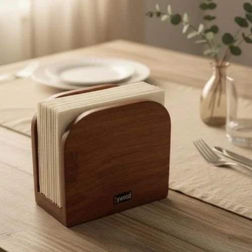 Wooden napkin holder with white napkins on a dining table. Elegant wooden napkin holder with white paper napkins for dining table decor.
