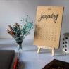 January 2022 desk calendar with minimalist design and wooden stand.